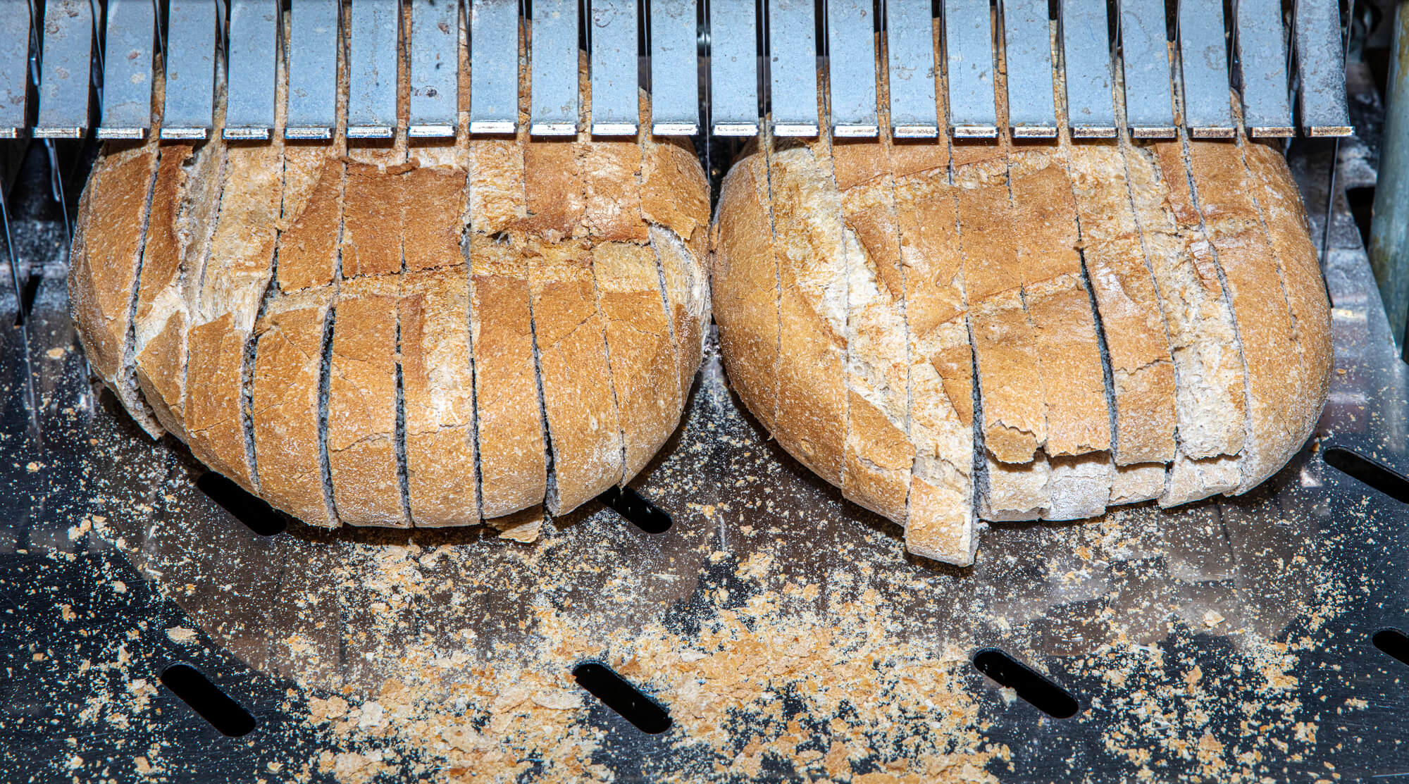 sliced bread under a bread slicer equipment