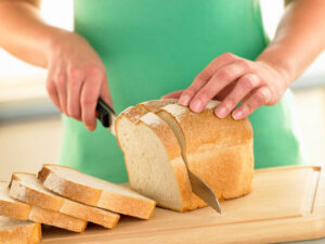 woman slicing bread using bread slicer equipment